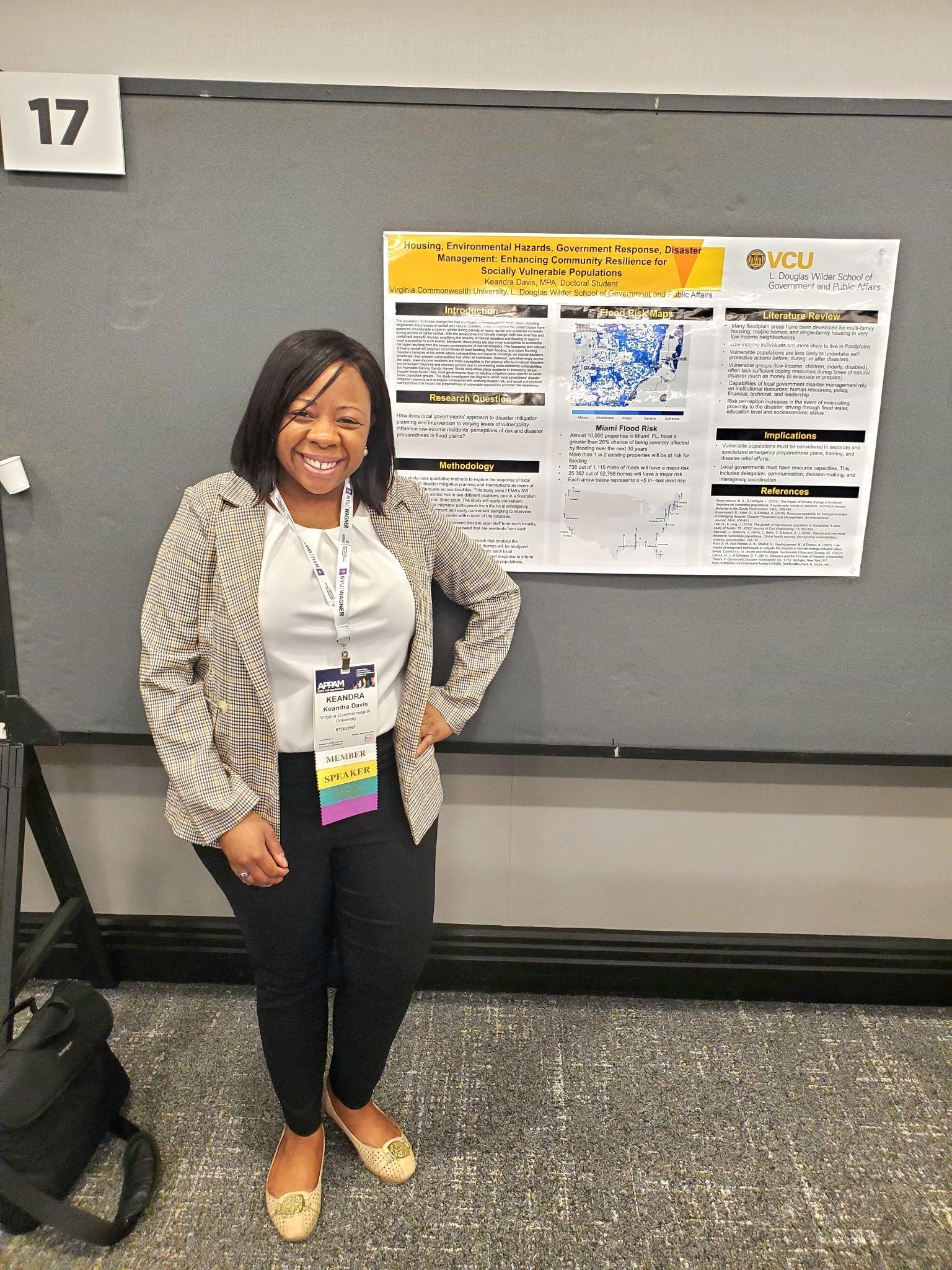 A woman presenting a research poster at a conference