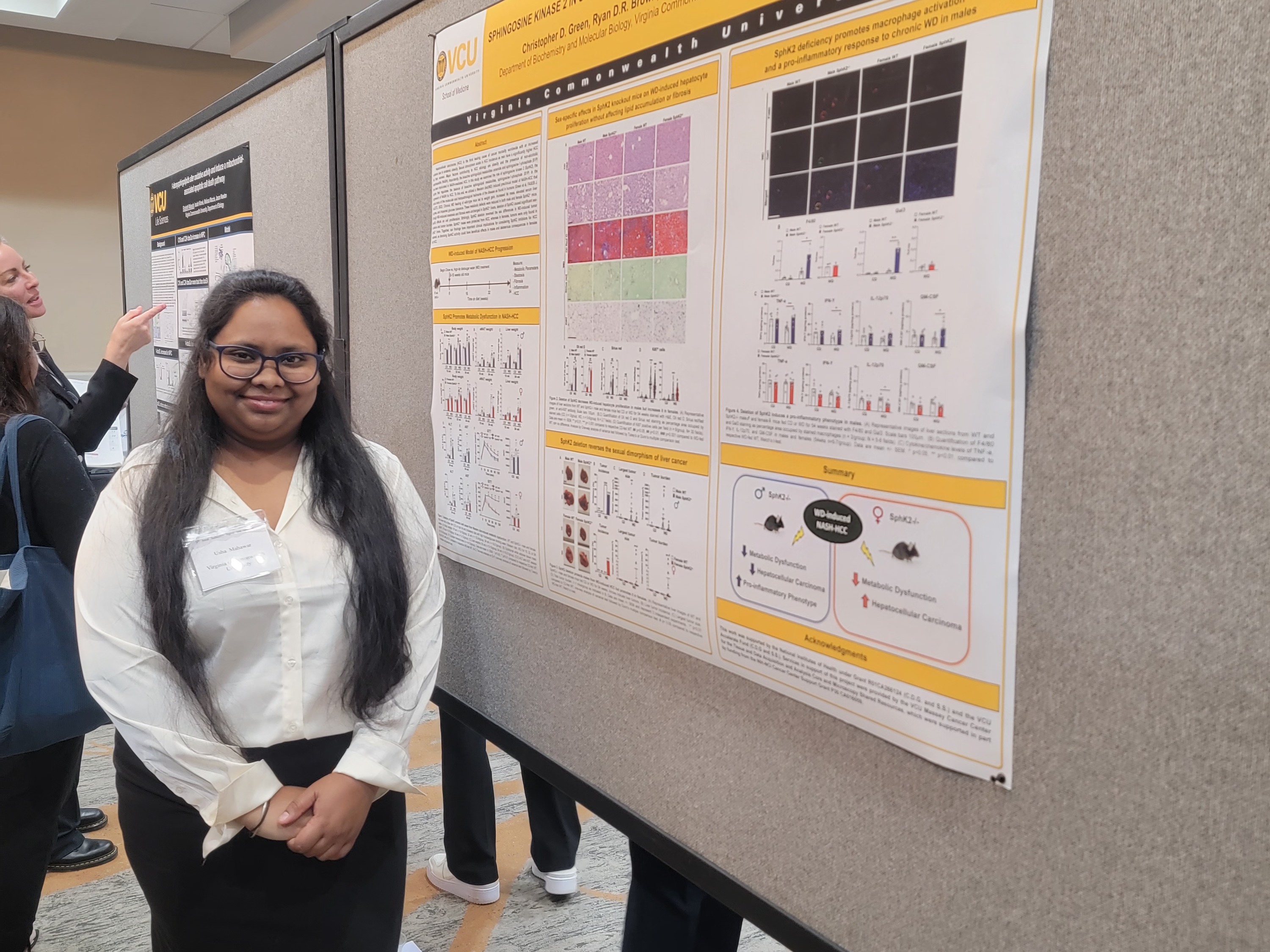 A student presenting their research poster at a conference